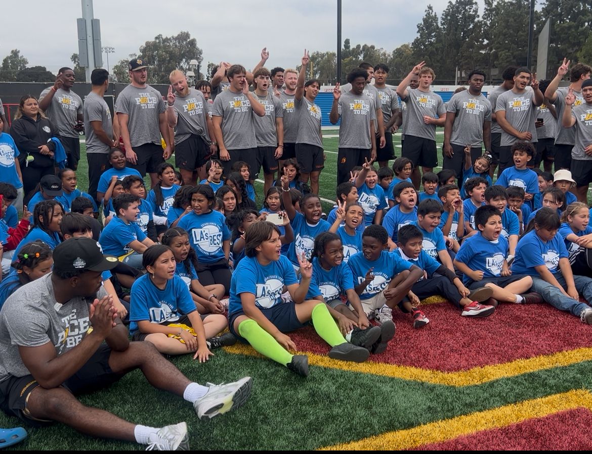 Kids with L.A.'s Best and USC athletes pose for the camera with a 