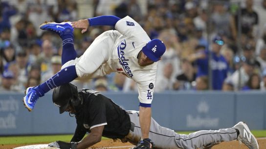 Los Angeles Dodgers third baseman Max Muncy (13) is injured as he flips over Chicago White Sox right fielder Michael A. Taylor (21) after tagging him out on an attempted steal in the fifth inning at D... 