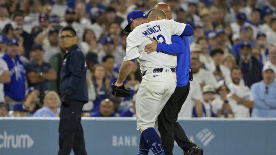 Los Angeles Dodgers third baseman Max Muncy (13) is helped off the field after he was injured on a play during the fifth inning against the Chicago White Sox at Dodger Stadium.