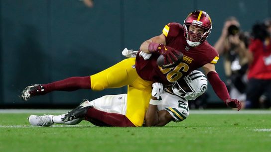 Washington Commanders tight end Zach Ertz (86) is tackled by Green Bay Packers cornerback Nate Hobbs (21) during a game on Sept. 11, 2025, at Lambeau Field in Green Bay, Wis. The Packers defeated the Commanders 27-18.