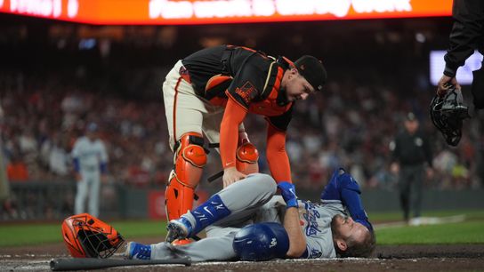 Los Angeles Dodgers third baseman Max Muncy (13) lays on the ground next to San Francisco Giants catcher Patrick Bailey (14) after being hit by a pitch in the sixth inning at Oracle Park. 