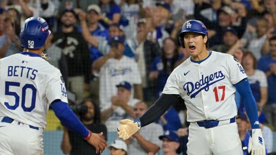 Los Angeles Dodgers shortstop Mookie Betts (50) and designated hitter Shohei Ohtani (17) celebrate after scoring against the Cincinnati Reds in the sixth inning during game two of the Wildcard round f... 
