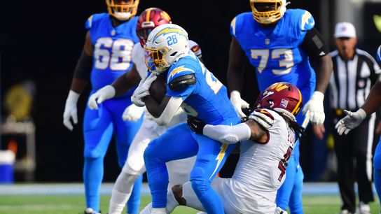 Oct 5, 2025; Inglewood, California, USA; Washington Commanders linebacker Frankie Luvu (4) tackles Los Angeles Chargers running back Hassan Haskins (28) in the second half at SoFi Stadium.