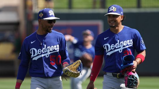 Los Angeles Dodgers shortstop Mookie Betts (50) and Santiago Espinal warm up before a game against the Colorado Rockies at Salt River Fields at Talking Stick. 