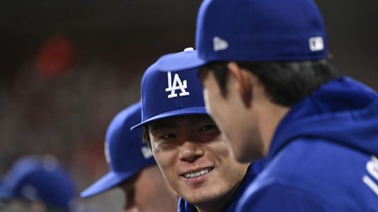 Los Angeles Dodgers pitcher Yoshinobu Yamamoto (18) speaks with a teammate during a game against the St. Louis Cardinals in the third inning at Busch Stadium. 