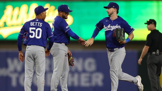 Los Angeles Dodgers shortstop Mookie Betts (50), Los Angeles Dodgers second baseman Miguel Rojas (72) celebrate the Dodgers win over the Athletics with Los Angeles Dodgers right fielder Kyle Tucker (2... Los Angeles Dodgers shortstop Mookie Betts (50), Los Angeles Dodgers second baseman Miguel Rojas (72) celebrate the Dodgers win over the Athletics with Los Angeles Dodgers right fielder Kyle Tucker (2...