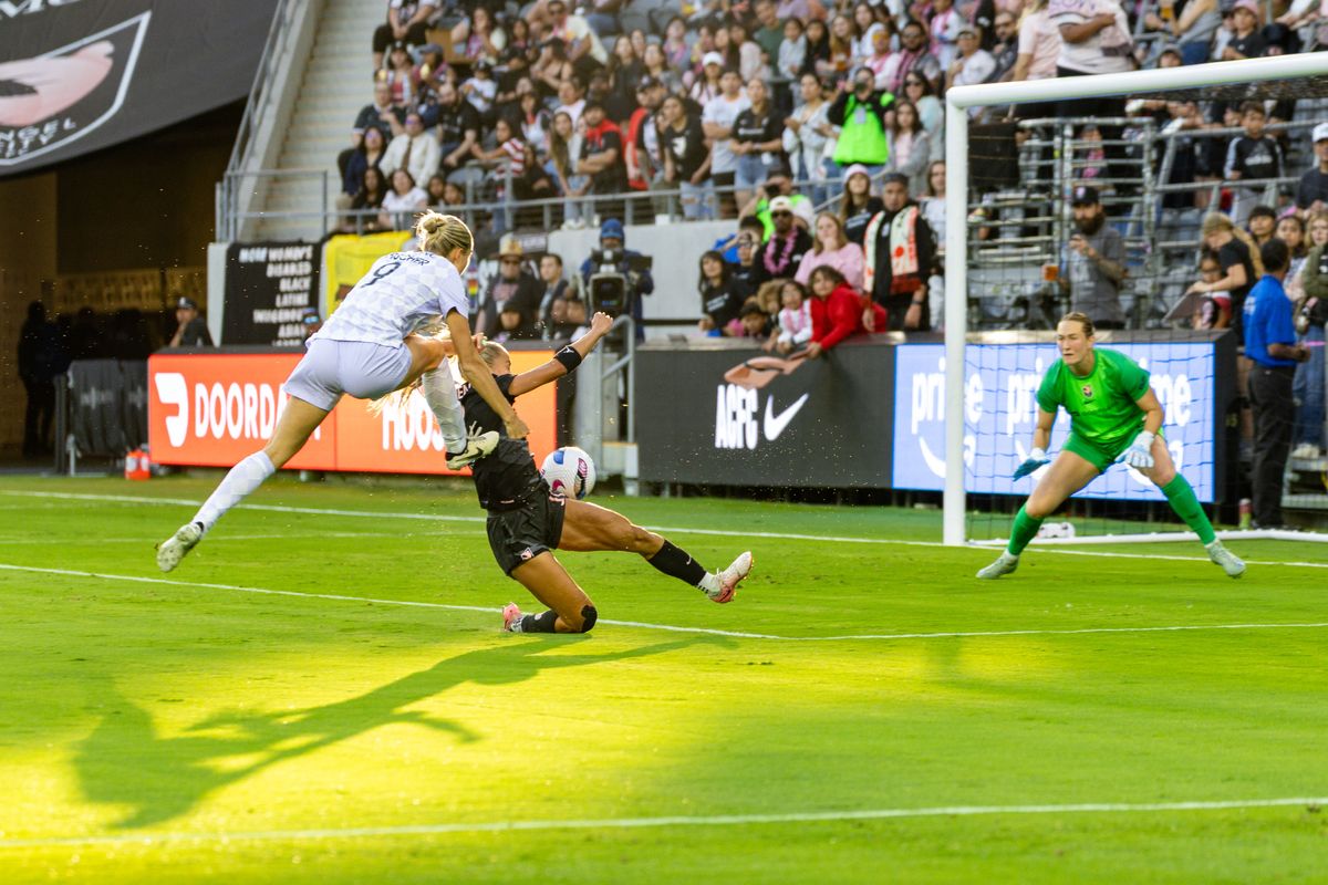 Angel City FC defender Sarah Gorden (11) makes a play on the shot by Racing Louisville FC midfielder Kayla Fischer (9) during an NWSL match, Saturday May 24, 2025 in Los Angeles, Calif.