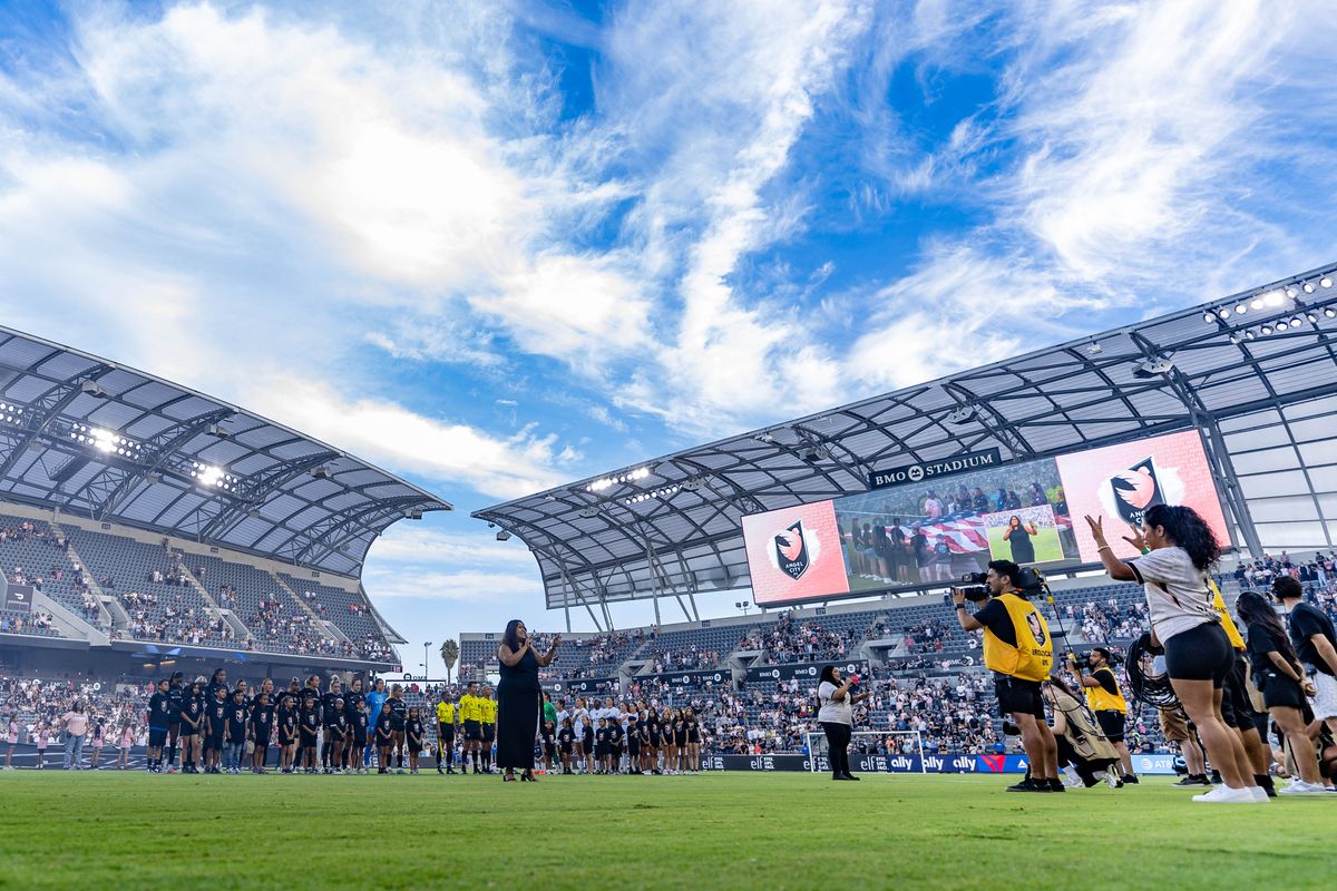 Angel City FC and Bay FC players line up for the national anthem before an NWSL match at BMO Stadium on September 1, 2025 in Los Angeles, California.