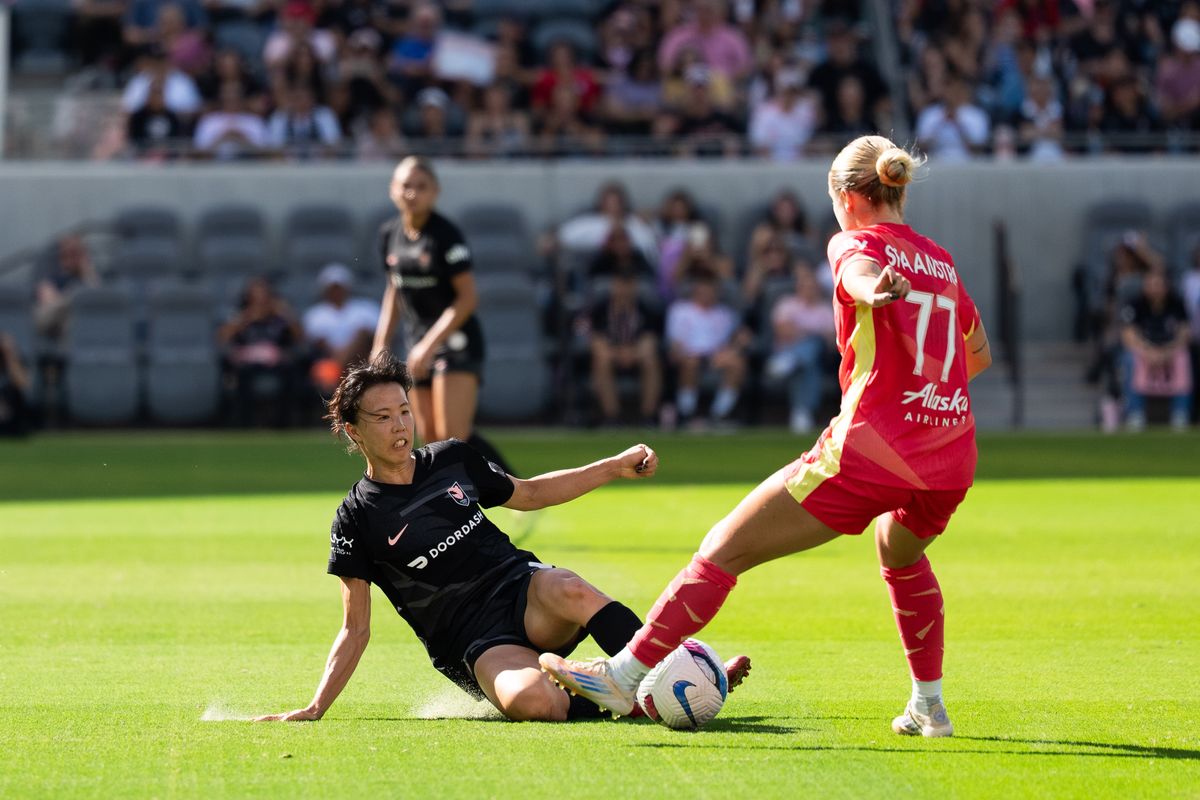 Angel City FC midfielder Hina Sugita slides to steal the ball from a Portland Thorns player, Sunday, Oct. 19, 2025, at BMO Stadium in Los Angeles, Calif.