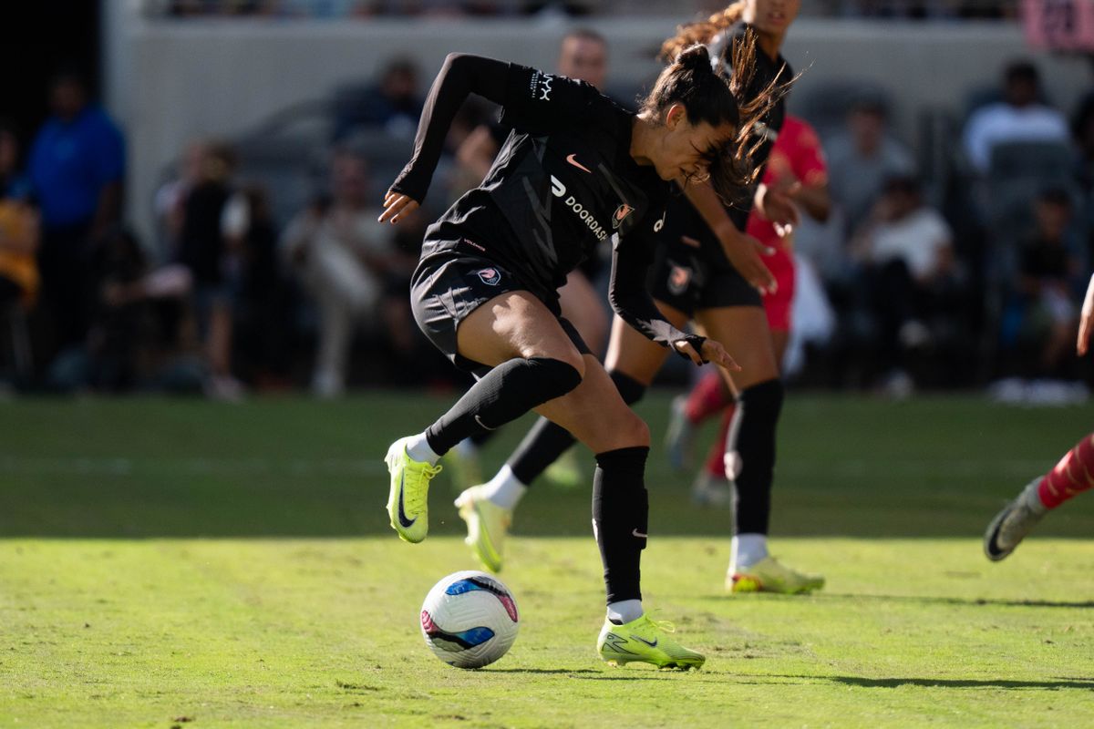 Angel City FC forward Christen Press (23) evades a Portland Thorns defender, Sunday, Oct. 19, 2025, at BMO Stadium in Los Angeles, Calif.