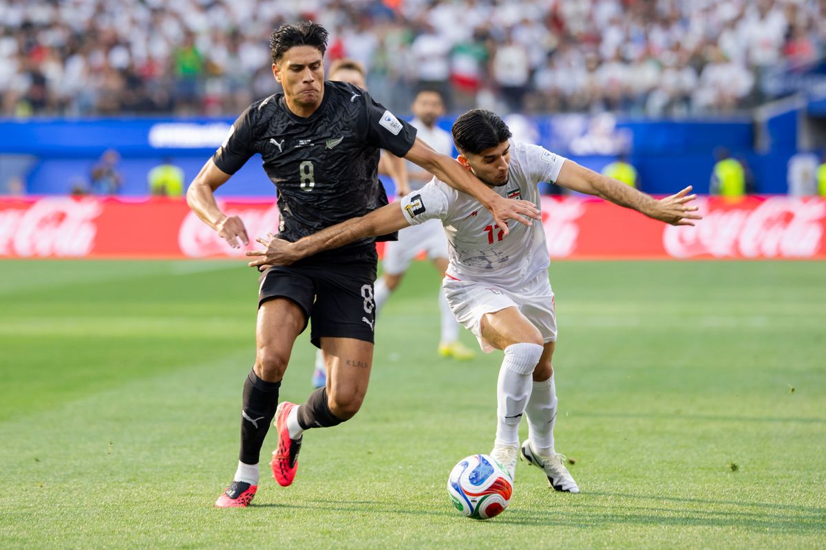 Marko Stamenić #8 of New Zealand and Arya Yousefi #17 of Iran battle for the ball during a 2026 FIFA World Cup match, Monday June 15, 2026 in Inglewood, Calif.