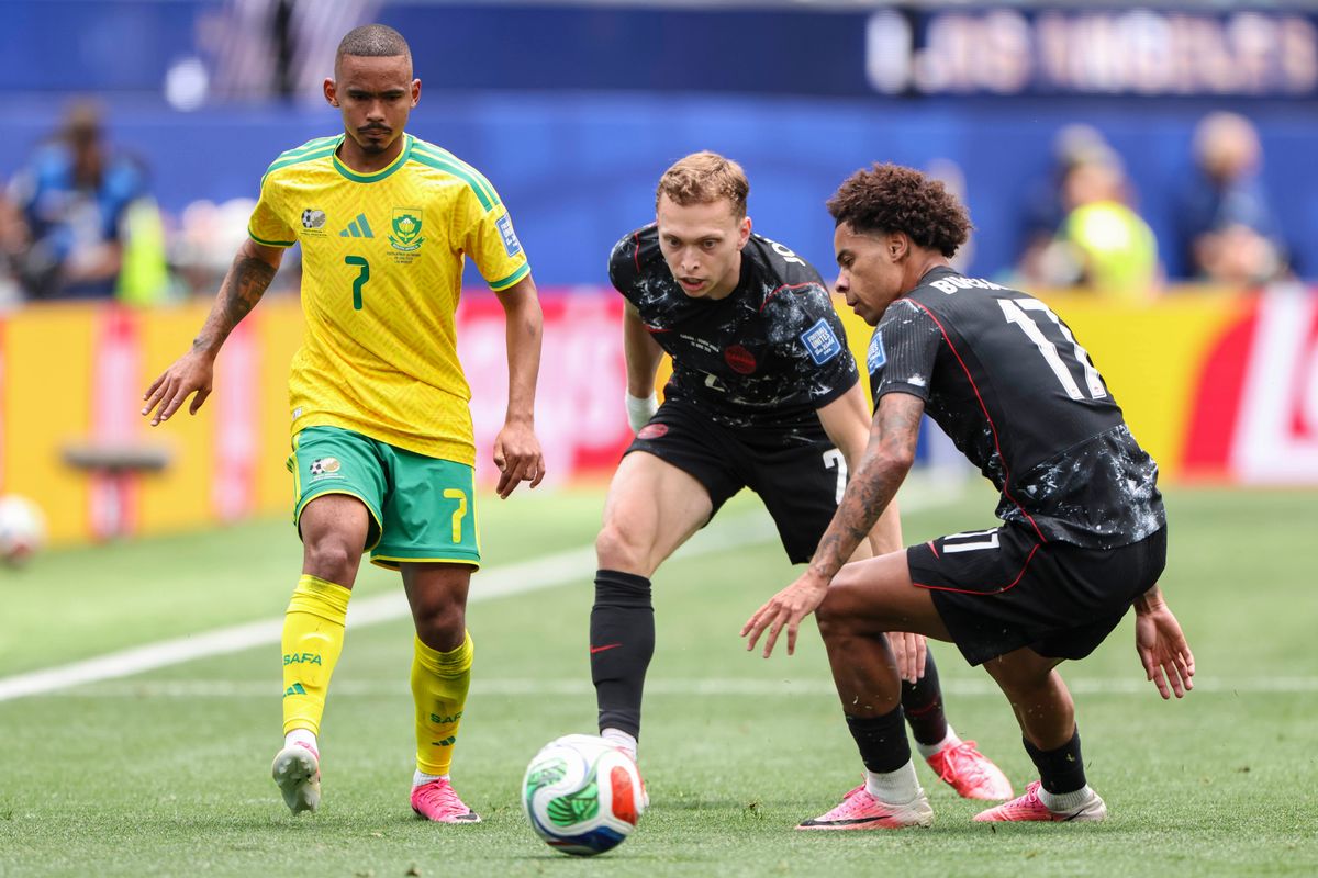 Oswin Appollis #7 of South Africa, Alistair Johnston #2 of Canada, and Tajon Buchanan #17 of Canada watch as the ball approaches during a 2026 FIFA World Cup match, Sunday June 28, 2026 in Inglewood, Calif.