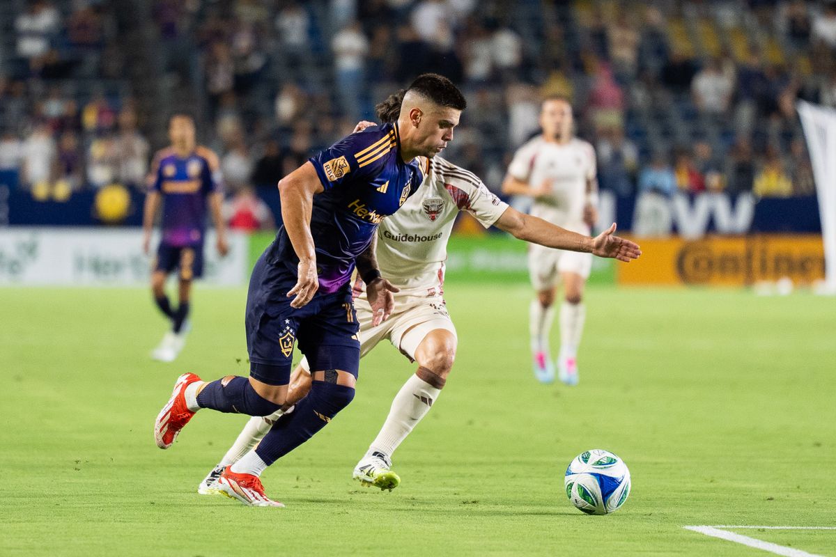 Los Angeles Galaxy forward Gabriel Pec (11) dribbles by defenders during an MLS match against D.C. United, Saturday July 12, 2025 in Carson, Calif.