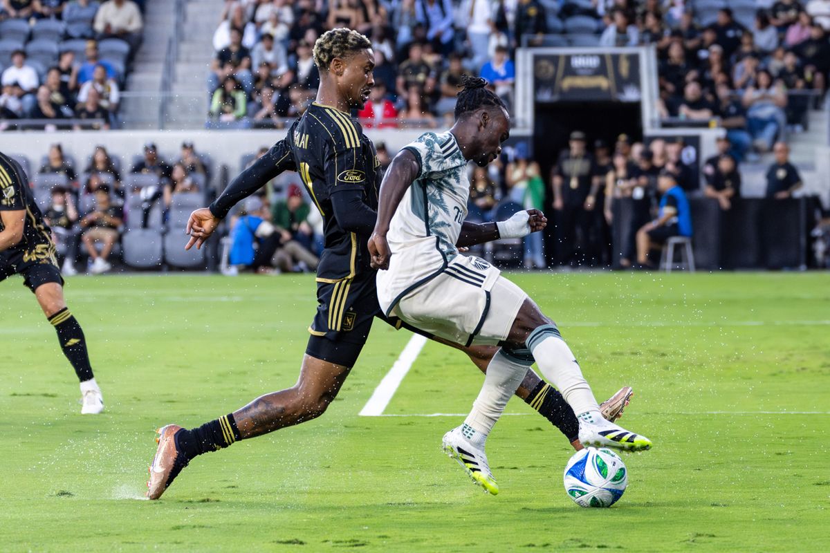 LAFC defender Nkosi Tafari (91) and Portland Timbers midfielder Santiago Moreno (30) fight for a ball during an MLS match, Friday July 25, 2025 in Los Angeles, Calif.