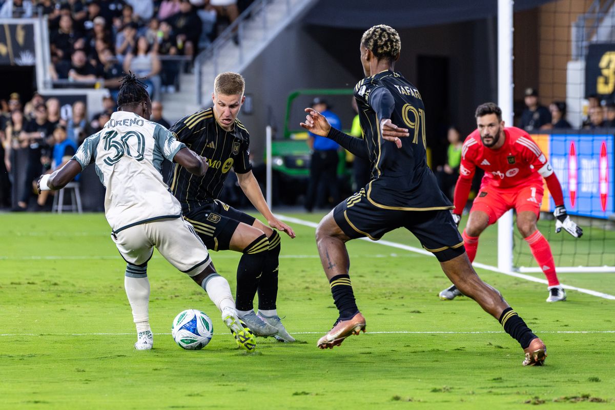 LAFC defender Artem Smolyakov (29) and Portland Timbers midfielder Santiago Moreno (30) go for a ball during an MLS match, Friday July 25, 2025 in Los Angeles, Calif.