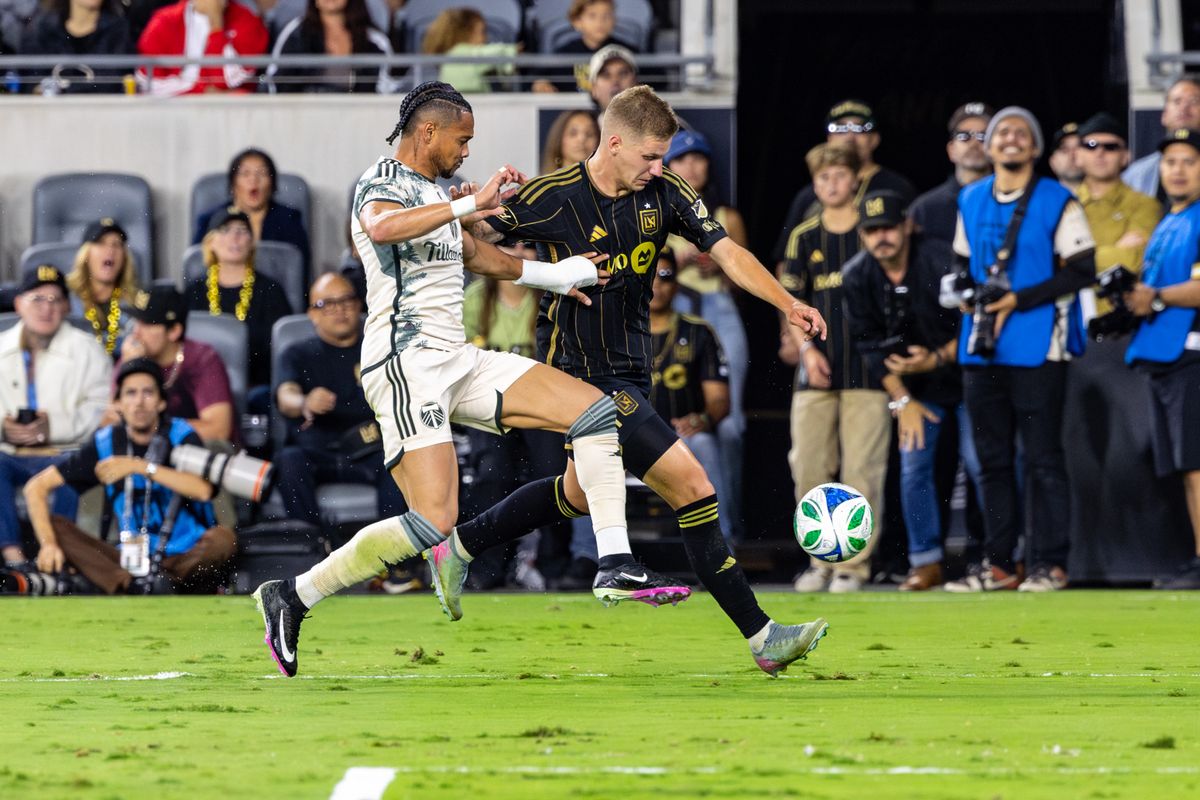 LAFC defender Artem Smolyakov (29) tries to get a shot past Portland Timbers forward Ariel Lassiter (7) during an MLS match, Friday July 25, 2025 in Los Angeles, Calif.