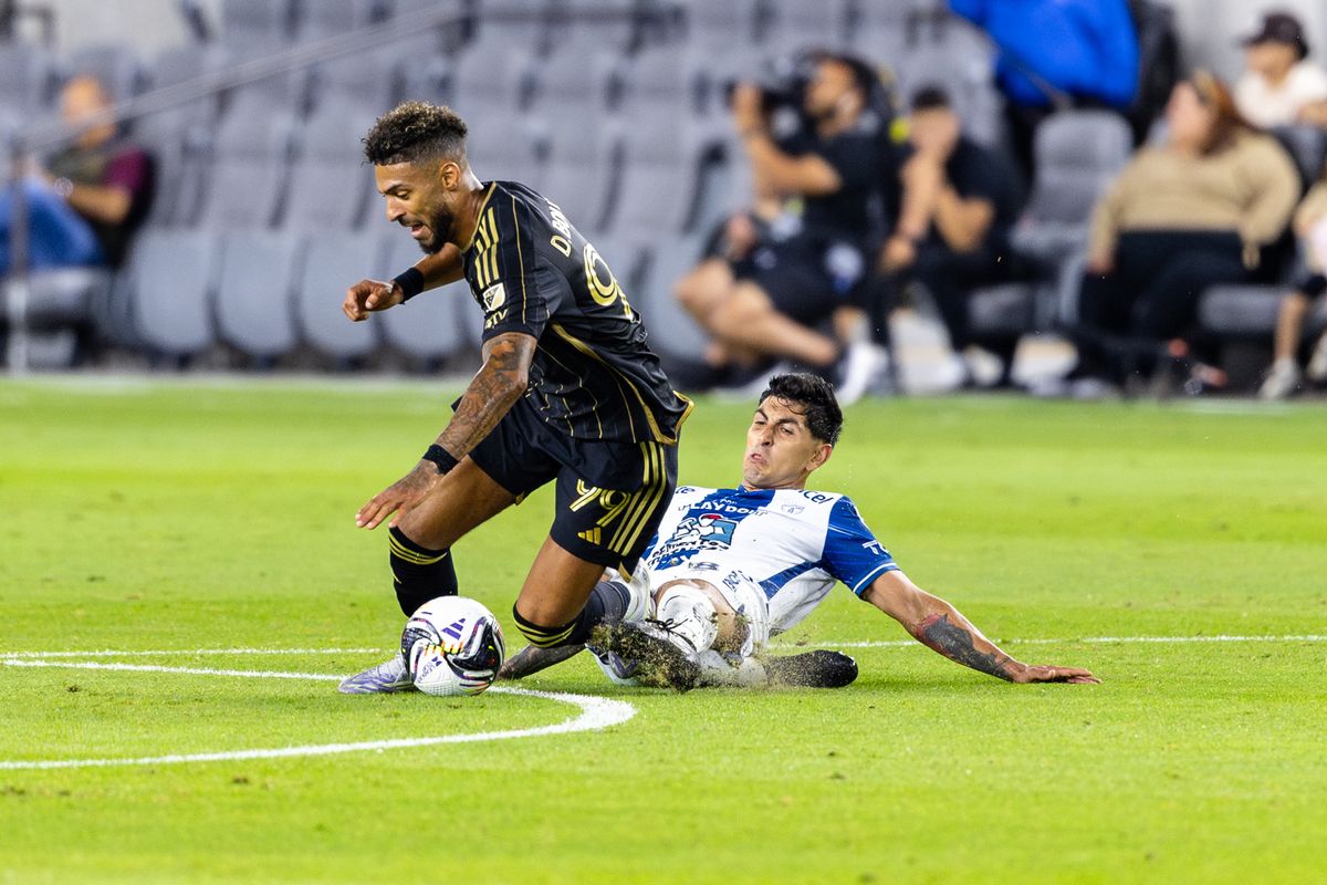 Pachuca midfielder Víctor Guzmán (8) slide tackles LAFC forward Denis Bouanga (99) during a Leagues Cup match, Friday August 1, 2025 in Los Angeles, Calif.