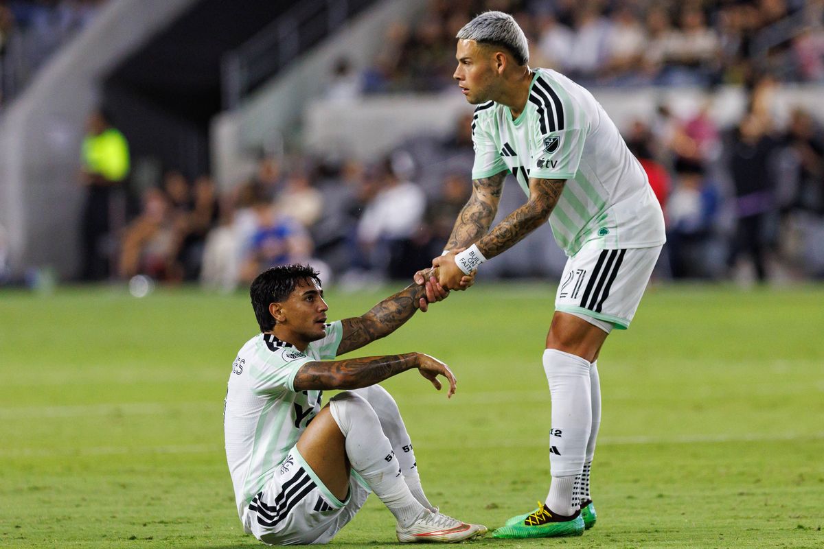 Christian Ramirez #21 of Austin FC helps up Facundo Torres #11 of Austin FC during an MLS regular season match against LAFC on October 14, 2026 at BMO Stadium in Los Angeles, California.