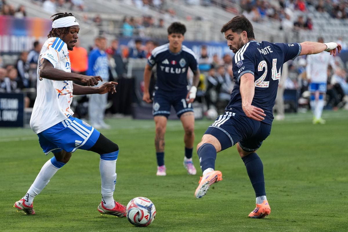 San Diego FC midfielder Manu Duah (26) dribbles past Vancouver Whitecaps forward Brian White (24) during an MLS soccer game against the Vancouver Whitecaps, Saturday May 23, 2026 in San Diego, California.
