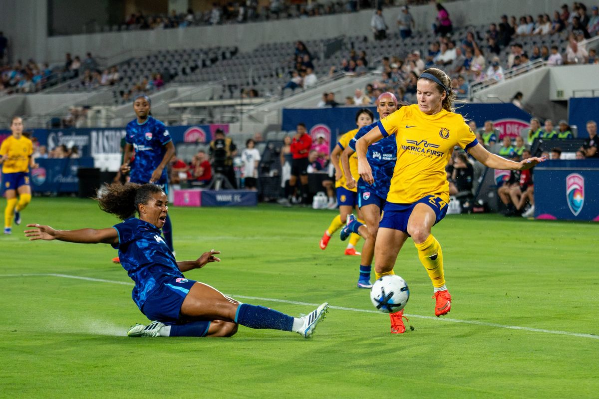San Diego Wave FC defender Kennedy Wesley (2) slides for the ball against Utah Royals FC striker Cloé Lacasse (24) during an NWSL game, Friday, August 21, 2026 in San Diego, California