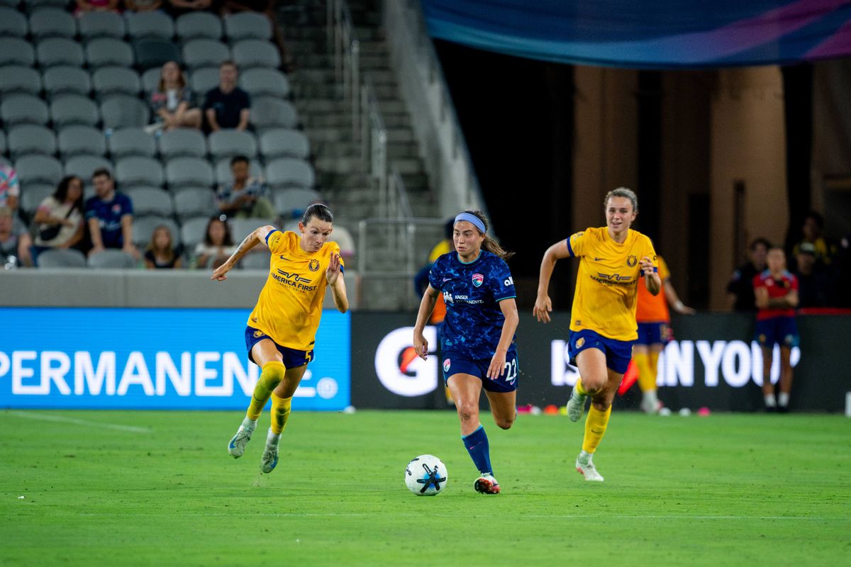 San Diego Wave FC midfielder Lia Godfrey dribbles away from opponents during an NWSL soccer game against Utah Royals FC, Friday, August 21, 2026, in San Diego, California.