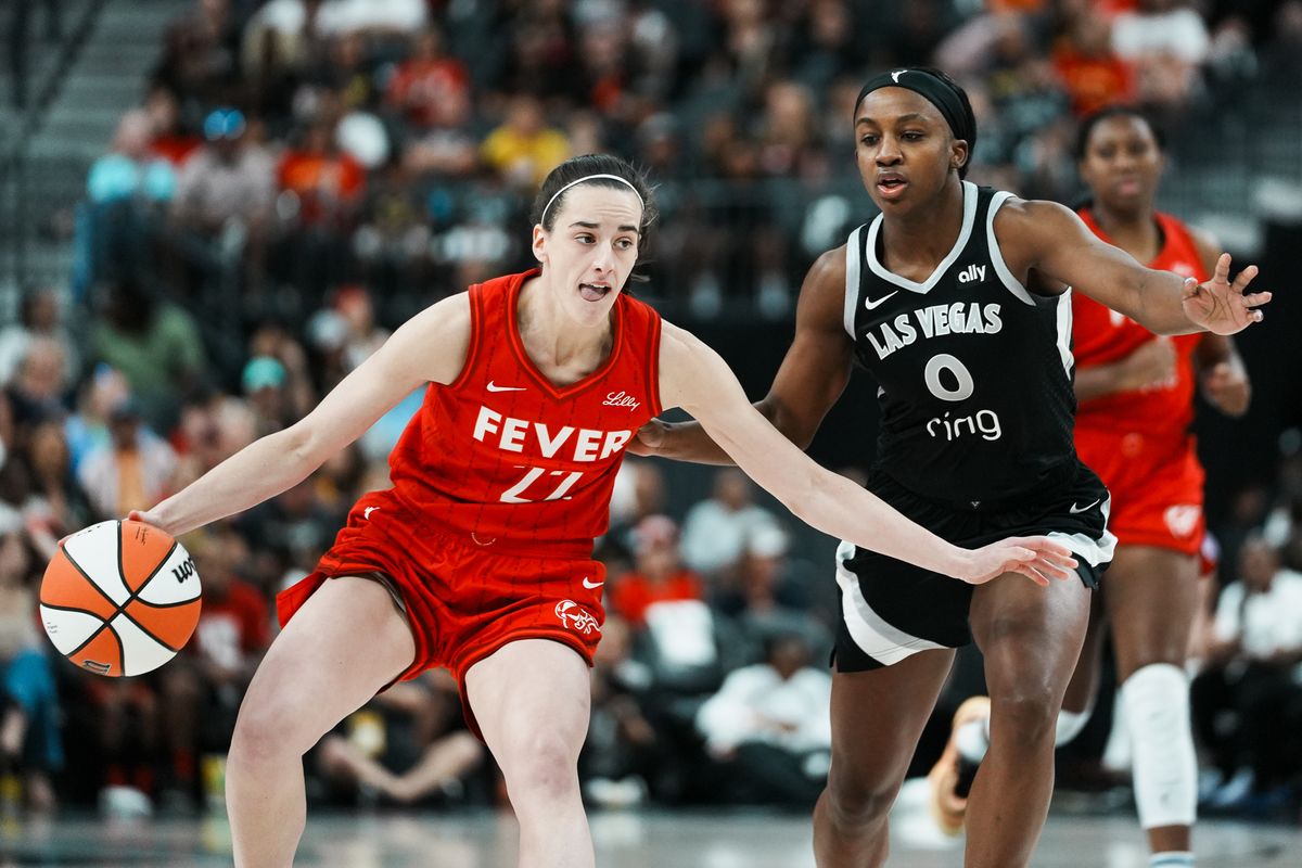 Indiana Fever guard Caitlin Clark (22) scans the court while guarded by Las Vegas Aces Jackie Young (0) during WNBA game against Las Vegas Aces on Sunday June 22, 2025 in Las Vegas.  