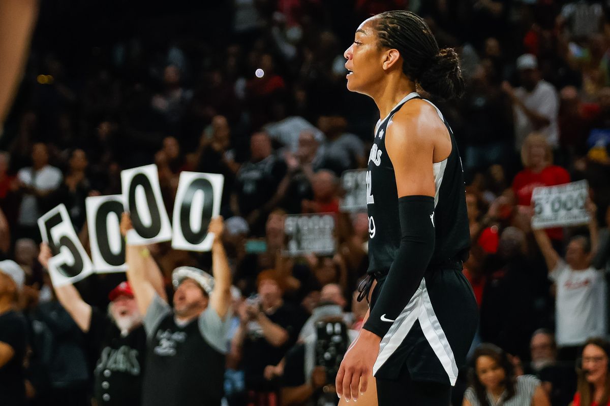 Fans raise a “5,000” sign behind Las Vegas Aces forward A’ja Wilson (22) after becoming the fastest WNBA player to score 5,000 points during a WNBA game between the Las Vegas Aces and the Connecticut Sun, Wednesday June 25, 2025 in Las Vegas, Nev.
