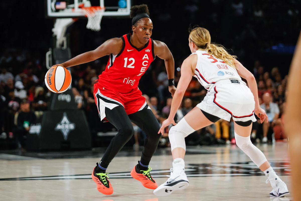 Las Vegas Aces guard Chelsea Gray (12) dribbles the ball as Washington Mystics guard Lucy Olsen (33) defends during a WNBA game between the Las Vegas Aces and the Washington Mystics, Thursday June 26, 2025 in Las Vegas, Nev.