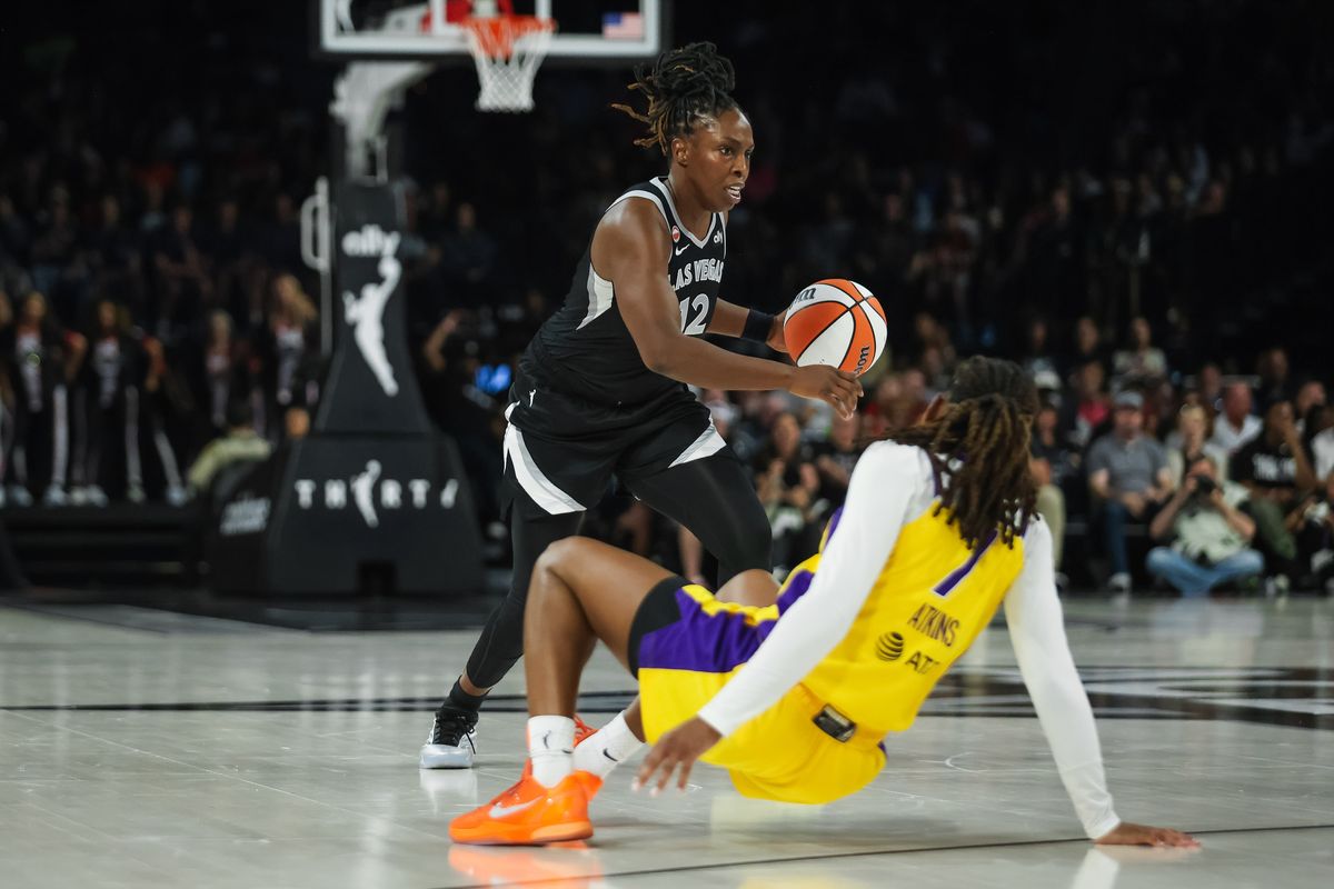 Las Vegas Aces guard Chelsea Gray (12) dribbles the ball as Los Angeles Sparks guard Ariel Atkins (7) trips during a WNBA game between the Las Vegas Aces and the Los Angeles Sparks, Saturday May 23, 2026 in Las Vegas, Nev.