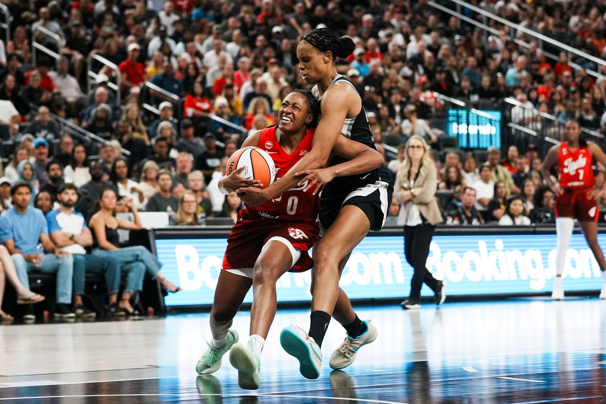Indiana Fever guard Kelsey Mitchell (0) attempts to drive through Aces forward Brianna Turner (7) towards the basket while during WNBA game against the Las Vegas Aces on Sunday July 5, 2026 at T-Mobile Arena in Las Vegas. Indiana Fever guard Kelsey Mitchell (0) attempts to drive through Aces forward Brianna Turner (7) towards the basket while during WNBA game against the Las Vegas Aces on Sunday July 5, 2026 at T-Mobile Arena in Las Vegas.