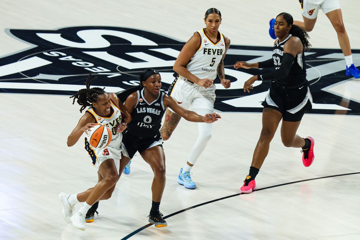 Las Vegas Aces guard Jackie Young (0) is charged with a foul against Indiana Fever guard Kelsey Mitchell (0) in the first quarter of Round 1 Game 1 of the 2026 WNBA Playoffs on Sunday, September 27, 2026, at Michelob ULTRA Arena in Las Vegas, Nevada.