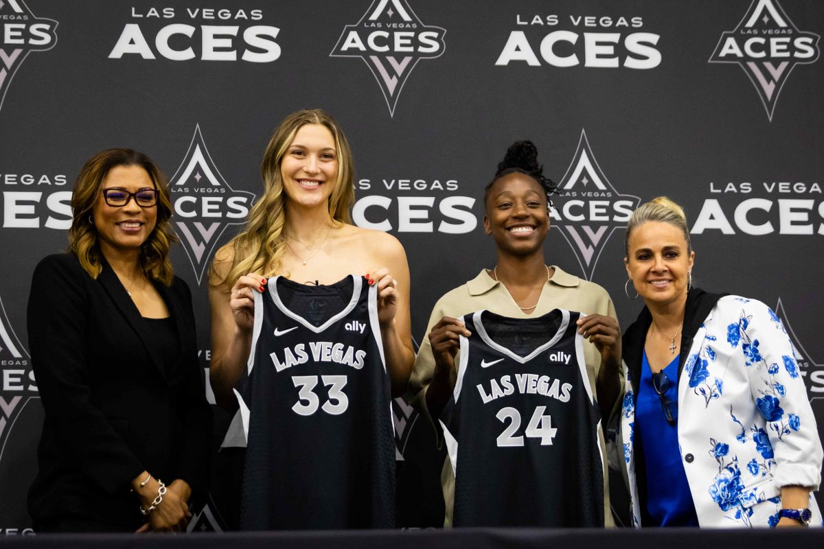 Las Vegas Aces Elizabeth Kitley and Jewell Lloyd pose with Aces jerseys alongside Aces president Nikki Vargas and Head Coach Becky Hammon during an introductory press conference, Tuesday February 25, 2025 in Las Vegas, Nev.